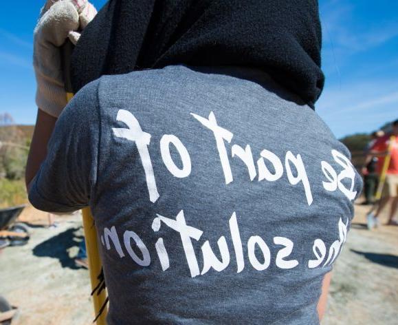 Pacific student volunteer wearing t-shirt that says, "Be part of the solution".